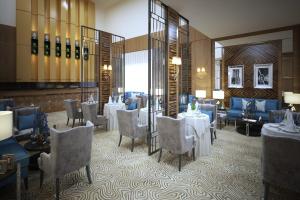 d'une salle à manger avec des tables et des chaises blanches et un porte-table. dans l'établissement Lavona Tiba Hotel, à Dammam