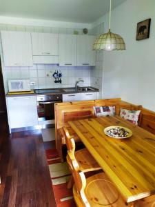 Plodn House في سابادا: مطبخ مع طاولة خشبية عليها لوحة