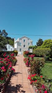 a house with pink flowers on a brick walkway at Casa Braña in Barreiros
