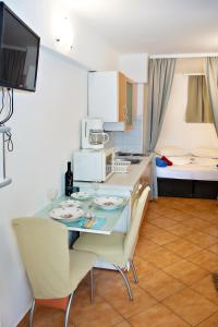 a kitchen with a table and chairs and a room at Apartments Ankica in Šibenik +65 photos
