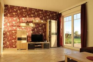 a living room with a refrigerator and a television at Ferienhaus bei Familie Gau in Schaprode (Ortsteil Poggenhof) in Schaprode