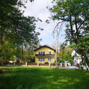 a yellow house with a fence in front of a yard at Seeblick Apartments Mühlau in Mühlau