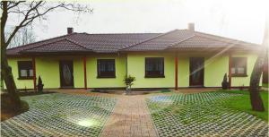 a yellow house with a brick courtyard in front of it at Ferienhaus bei Familie Gau in Schaprode (Ortsteil Poggenhof) in Schaprode