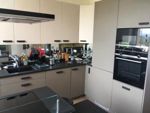 a kitchen with white cabinets and a black counter top at Résidence Le Château - Parc Santa Lucia in Saint-Raphaël