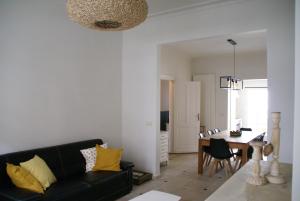 a living room with a black couch and a dining room at Au Coeur de la Famille in Knokke-Heist