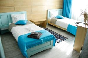 a bedroom with two beds with blue and white at Pensiunea La Marcu Modern in Tulcea