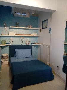 una camera con letto blu e scaffali di Little Paradise casa vacanze a Margherita di Savoia