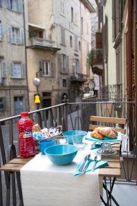 Casa Vacanze Gombito 4 Bergamo Alta في بيرغامو: طاولة مع أطباق من الطعام على شرفة