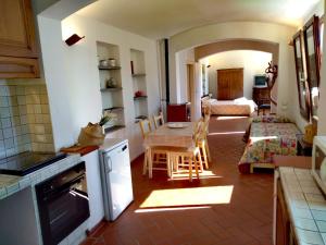 a kitchen and living room with a table and chairs at ROMANTICA TOSCANA in Scarlino