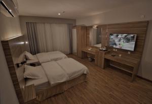 een slaapkamer met een bed en een televisie. bij ساس رتل للوحدات السكنية المفروشة in Al Madinah