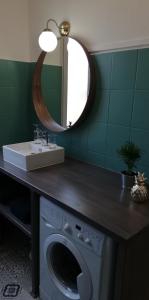 a bathroom with a washing machine and a mirror at Gîte, le Colmar Vintage Station in Colmar