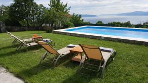 two chairs and a table next to a swimming pool at Casa Bellavista in Rijeka