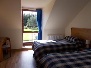 a bedroom with two beds and a window at Forest View in Fraserburgh