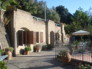 a brick building with a gate and potted plants at ROMANTICA TOSCANA in Scarlino