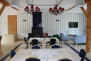 a dining room with tables and chairs and a couch at Aronia Park in Lubiechowa