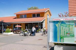 a sign in front of a building with people standing outside at Zuiderzee-chalet 22 in Molkwerum