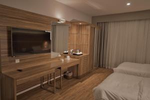 een slaapkamer met een bed en een bureau met een televisie bij ساس رتل للوحدات السكنية المفروشة in Al Madinah +102 foto's