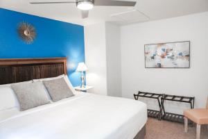 a bedroom with a white bed and a blue wall at The Eden House Vineyard in Templeton