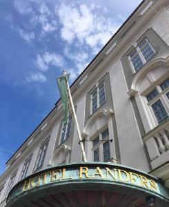 un edificio con una bandiera che batte di fronte ad esso di Hotel Randers a Randers