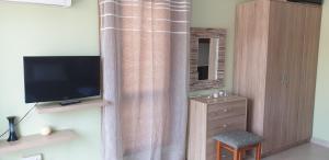 a room with a television and a dresser with a curtain at EMILIA 11 STUDIO in Polis Chrysochous