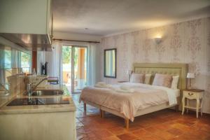 a bedroom with a bed and a kitchen with a sink at Moonshine Guest House with private studios and private cottage in Lagos +65 photos