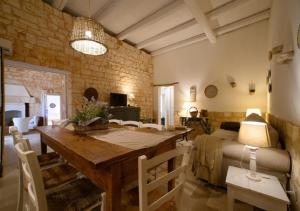 ein Wohnzimmer mit einem Holztisch und einem Bett in der Unterkunft Masseria Montefieno in Castellana Grotte