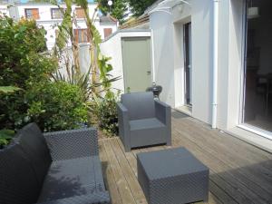 a patio with two chairs and a table on a deck at côte et mer in Sainte-Adresse