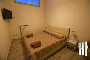 1 dormitorio con 1 cama y TV en la pared en Tra le Colonne, en Pozzuoli