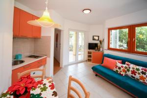 a living room with a blue couch and a kitchen at Apartments Dvori Novalja in Novalja