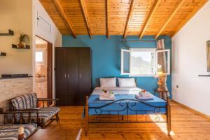 a bedroom with a bed with a blue wall at Malotu Resort in Sinarádes