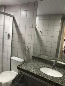 a bathroom with a sink and a toilet at Luzon Residence Apartments in Fortaleza