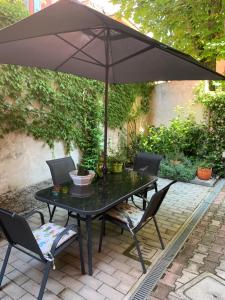 - une table noire avec des chaises et un parasol sur la terrasse dans l'établissement Casa Pepe, à Bologne