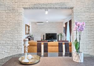 a living room with a couch and a table with flowers at Apartment Villa Hacijenda with private pool and jacuzzi in Kaštela
