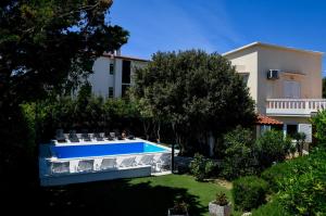 a swimming pool in a yard next to a building at Apartments Dvori Novalja in Novalja