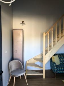 a room with a staircase and a chair and a spider on the wall at Duplex avec piscine in Villenave-dʼOrnon