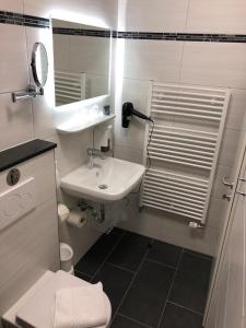 ein Badezimmer mit einem Waschbecken, einem WC und einem Spiegel in der Unterkunft Altes Winzerhaus in Cochem