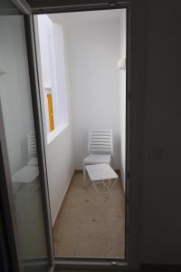 krzesło siedzące w pokoju z oknem w obiekcie Hostal Cala Ratjada w Cala Ratjada +37 zdjęć