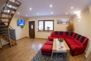 a living room with a red couch and a table at Noclegi u Bartka i Magdy in Solina