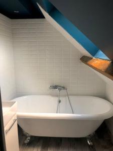 a white bath tub in a bathroom with a blue ceiling at Le Duplex in Cherbourg en Cotentin +9 photos