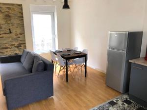 a living room with a couch and a table and a refrigerator at Le Duplex in Cherbourg en Cotentin