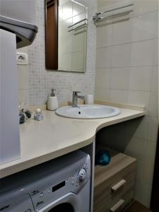 een badkamer met een wastafel en een wasmachine bij La Pietra Antica in Paola