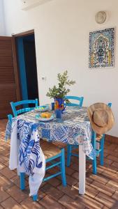 einen Esstisch mit einem blauen und weißen Tischtuch in der Unterkunft Casa Paola in Favignana