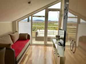 Una sala de estar con un sofá y una ventana grande. en Sun&Sea Apartment, en Vodice 5 fotos más