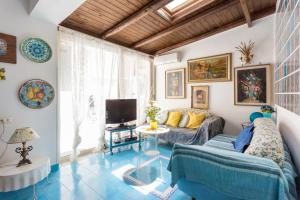 sala de estar con sofá y TV en Splendida Casa A Taormina " Casa di Anna ", en Taormina