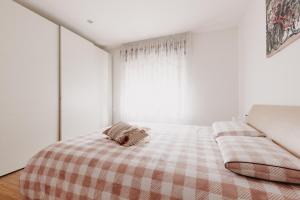 - une chambre dotée d'un lit avec une couverture tressée et une fenêtre dans l'établissement ROSE GARDEN, à Tezze