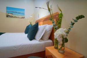 a bedroom with a bed with blue and white pillows at Piccadilly Rooms Restaurant and Beach in Santa Maria al Bagno