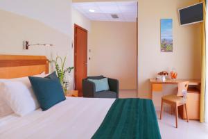 a bedroom with a bed and a desk and a chair at Piccadilly Rooms Restaurant and Beach in Santa Maria al Bagno