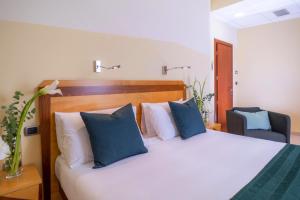 a bedroom with a bed with blue and white pillows at Piccadilly Rooms Restaurant and Beach in Santa Maria al Bagno