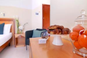 a table with a plate of donuts and a glass jar at Piccadilly Rooms Restaurant and Beach in Santa Maria al Bagno