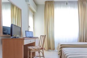 a bedroom with a desk with a television and a bed at Hotel Jollino in Pineto
